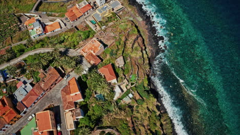 drone aéreo disparado sobre la costa de la palma, islas canarias, españa. alta vista del océano turquesa, costa accidentada, plantaciones de plátanos y la pequeña ciudad local. destino de vacaciones de verano.