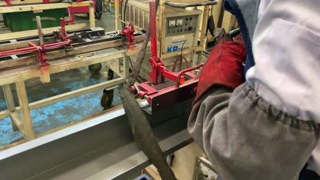 close-up of man using semi-automatic welding machine