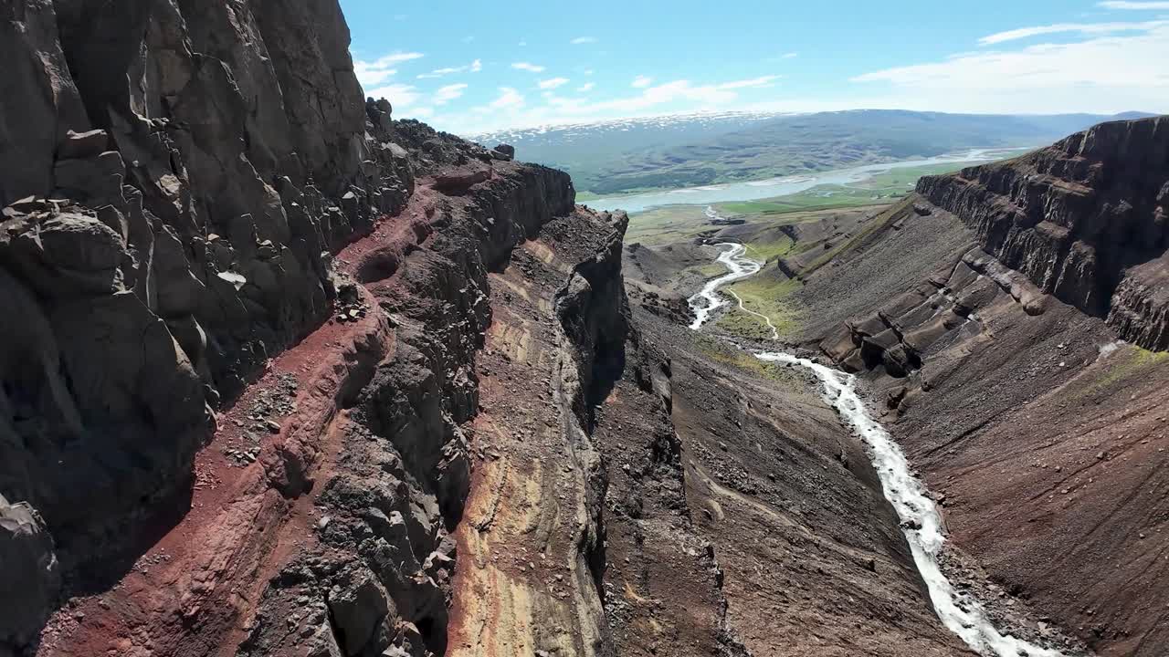 İzlanda'nın Egilsstaðir yakınlarındaki Hengifoss'ta FPV drone, geniş kanyona dalıyor, yükselen bazalt kayalıkların yanından geçiyor ve hızlı, sinematik bir yaz hava çekimiyle şelaleye doğru alçalıyor.