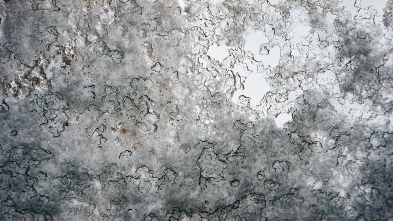 Close-up van een ijzig of berijpt oppervlak met fijne textuur en zachte blauwe tinten
