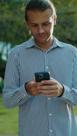 young man engaged with smartphone outdoors