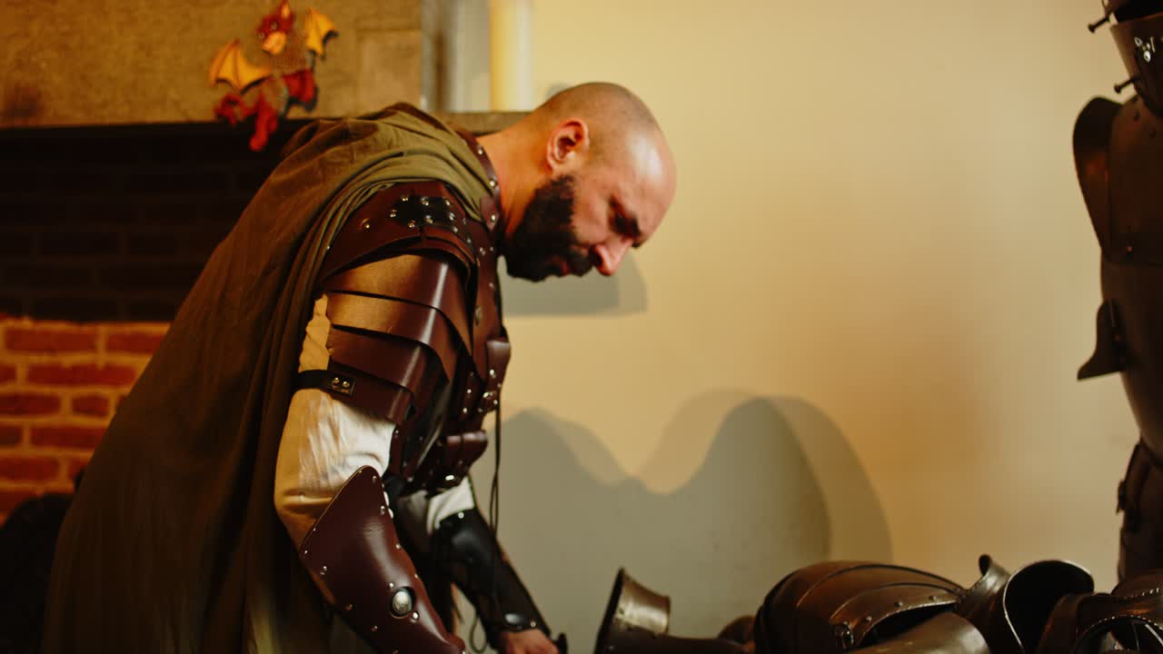 un caballero de aspecto duro limpiando su equipo en una armería medieval