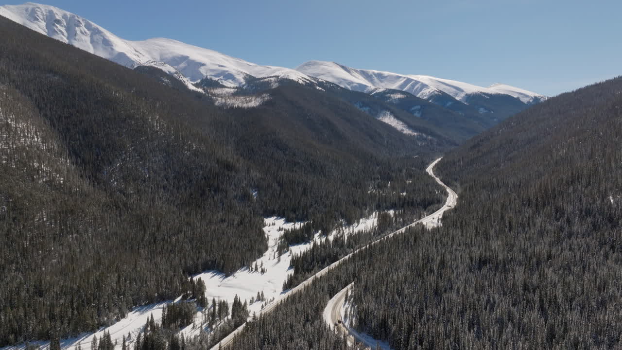 toma aérea inclinada de autos conduciendo cerca del parque de invierno en colorado