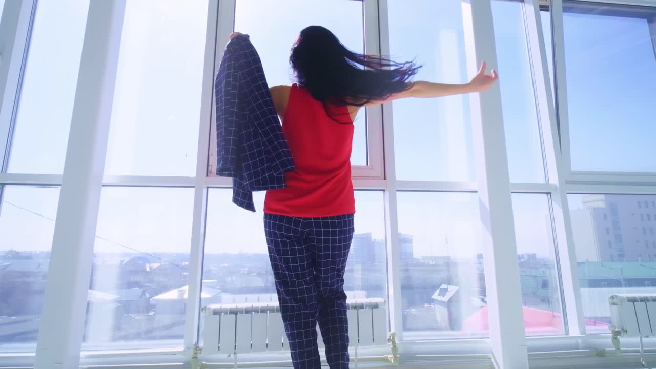 A confident woman transitions from a serene morning in pajamas to a bright and cheerful moment, showcasing the beauty of self-assurance and joy in a sunlit room