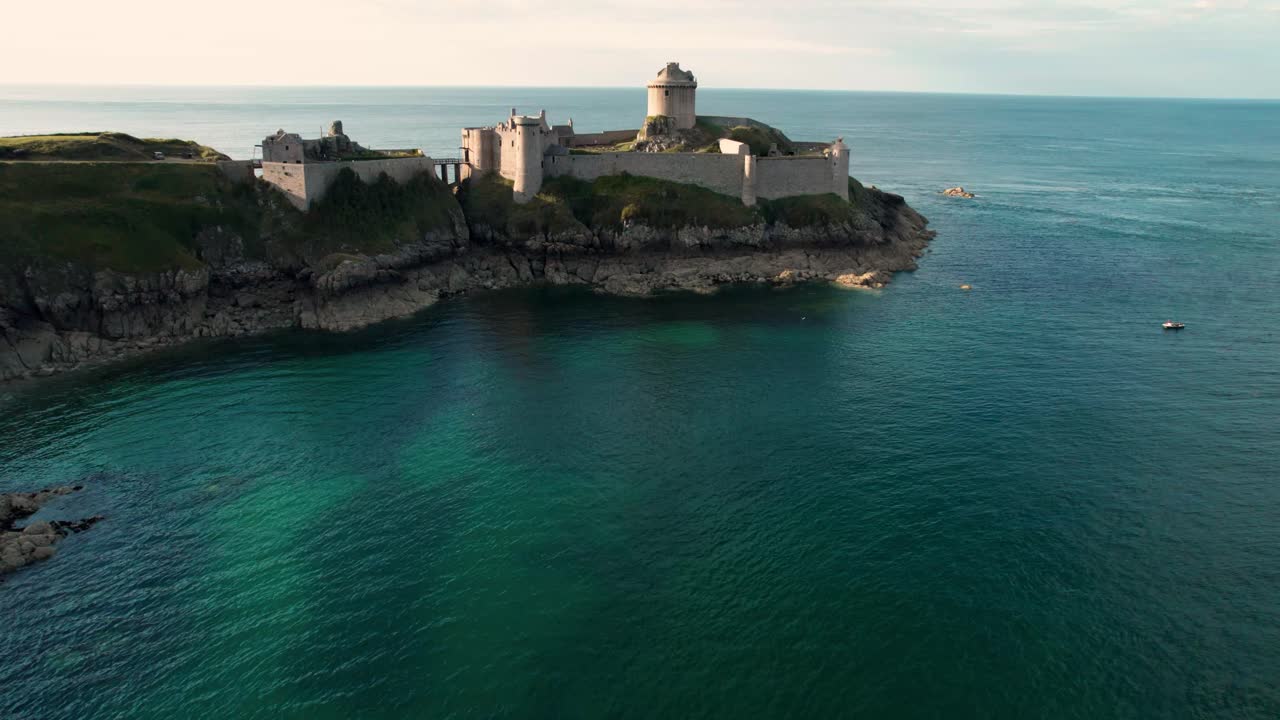 epic drone shot around Fort La Latte Castle, Chateau de la Roche Guyon, on the Brittany coast with Cap Frehel in the background, Cotes d'Armor, France