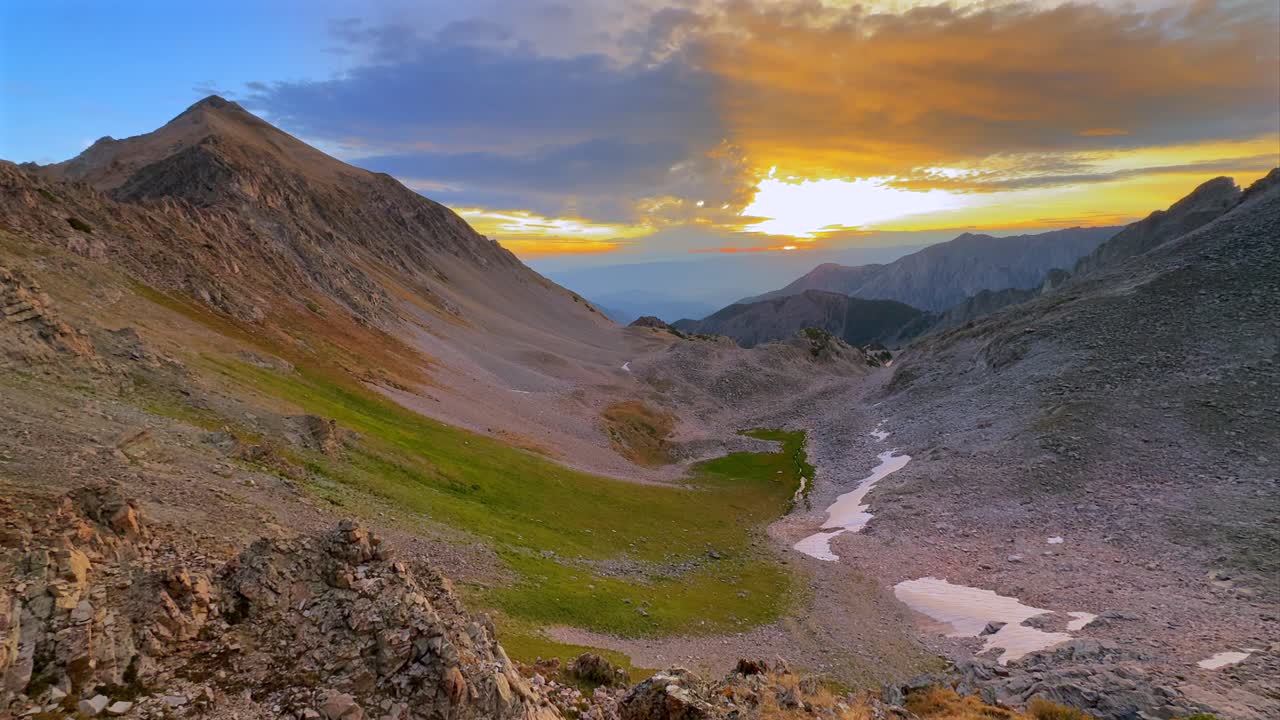 Aspen Snowmass Wilderness vibrant sunrise Capitol Peak Trailhead Ridge route Mt Daly K2 Colorado Rocky Mountain Elk Range scenic nature landscape high alpine elevation sun ray clouds pan right motion