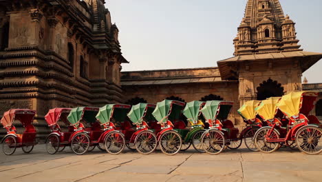 colorful rickshaws parked in front of an indian temple