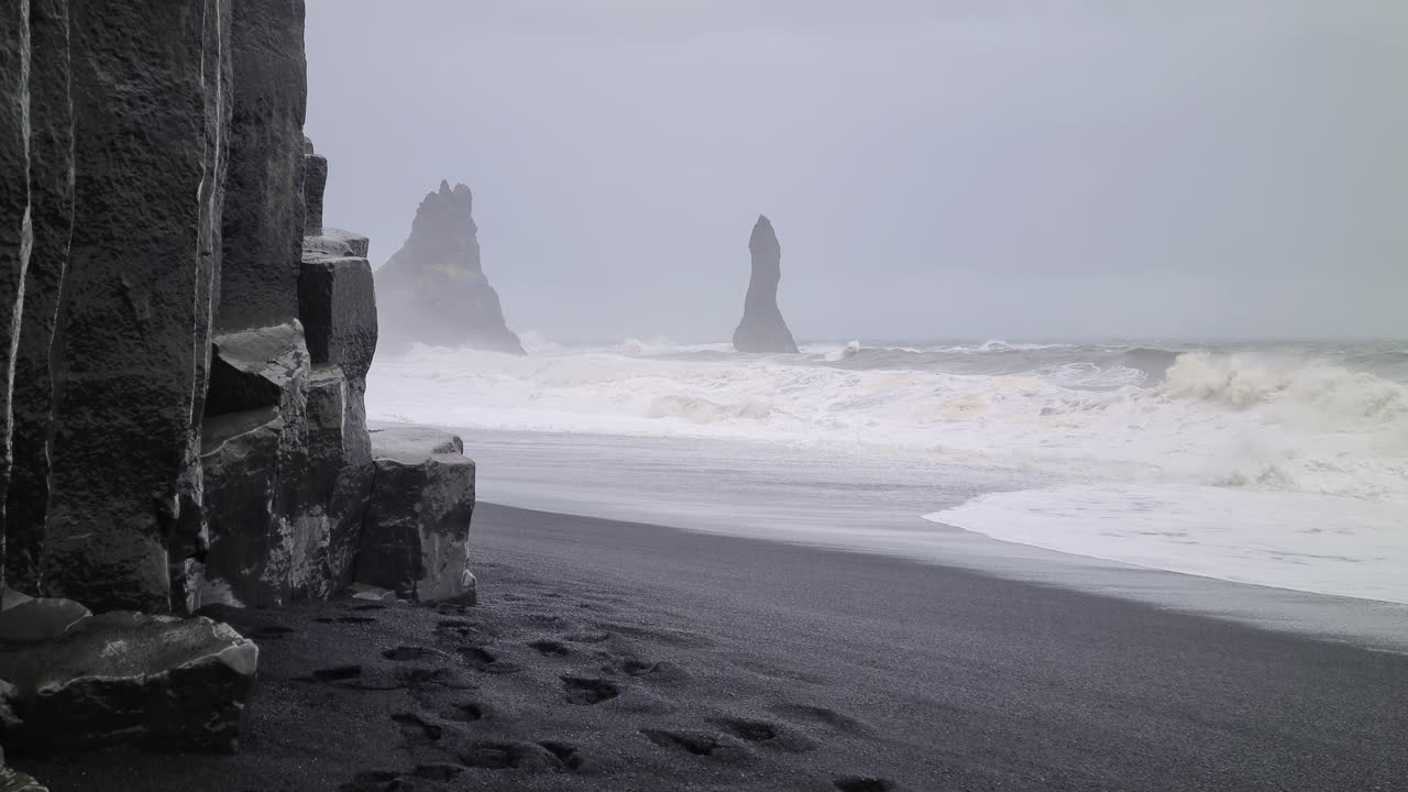 playa de arena negra, clima duro con lluvia y olas violentas del mar, costa de islandia