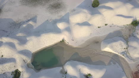 white sand dunes on the ocean shore seen from a low altitude drone flight at malaysia, melaka.
