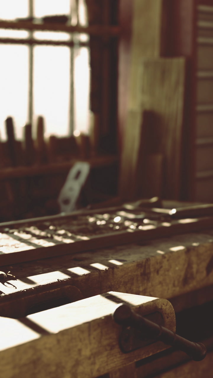 Woodworking tools are arranged on a workbench in a bright workshop