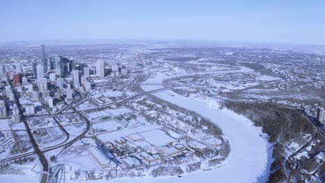 En-Lo-Alto-De-La-Antena-Durante-El-Invierno,-El-Centro-De-La-Ciudad-Panout-De-Edmonton,-Alberta,-Canadá,-Con-El-Río-Saskatchewan-Norte-Cubierto-De-Nieve,-Con-Carreteras,-Puentes,-Parque-Forestal,-Impresionantes-Cielos-Despejados