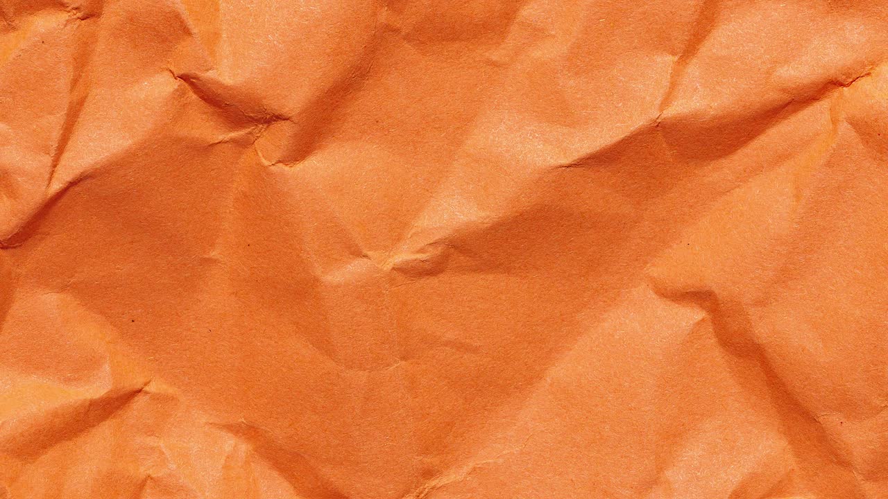 Stop motion animation of crumpled orange paper, creating a looping textured background