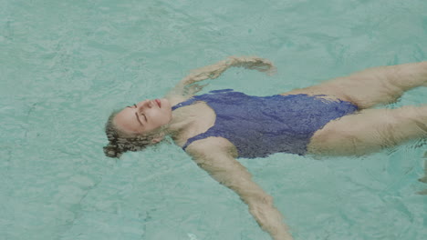 mujer relajándose en el agua en la piscina