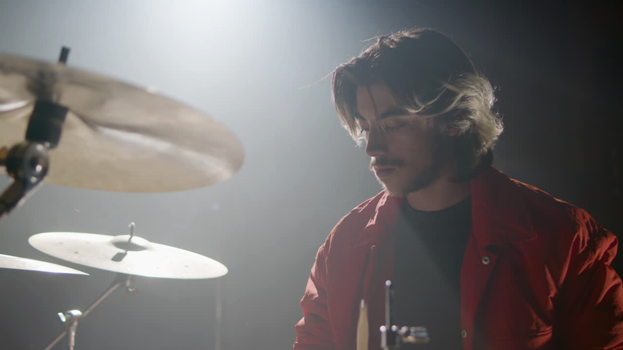 joven baterista tocando la batería en un estudio de música