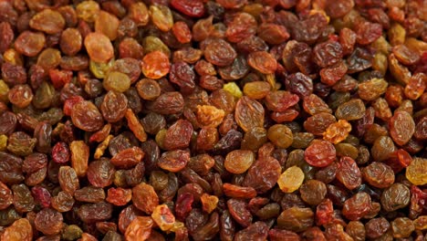 looped spinning full frame background of yellow and brown raisins pile