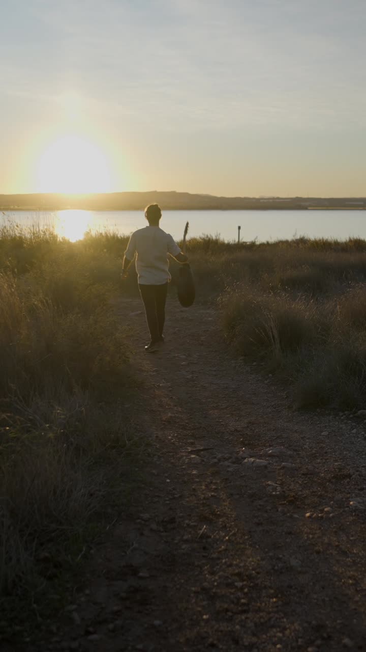 Musician with Guitar at Sunset by the Lake