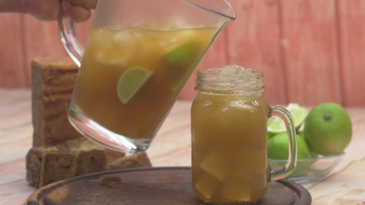 Vertiendo limonada venezolana en un tarro de cristal, bebida refrescante al aire libre