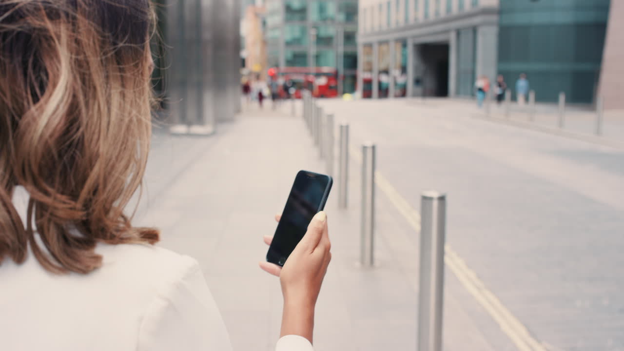 mujer usando teléfono inteligente en la calle de la ciudad