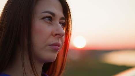 upset woman stands against red evening sun closeup dark haired lady thinks about life difficulties