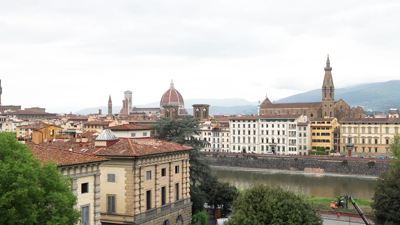 Vista panoramica dello skyline storico di Firenze, con il Duomo, i campanili, i classici tetti toscani e il fiume Arno, sotto una luce diurna soffusa. Grandangolo, movimento sottile, nessuna persona visibile.