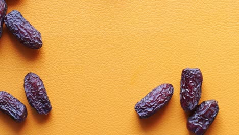 Top-view-of-slow-motion-of-date-fruits-dropping-on-table-,