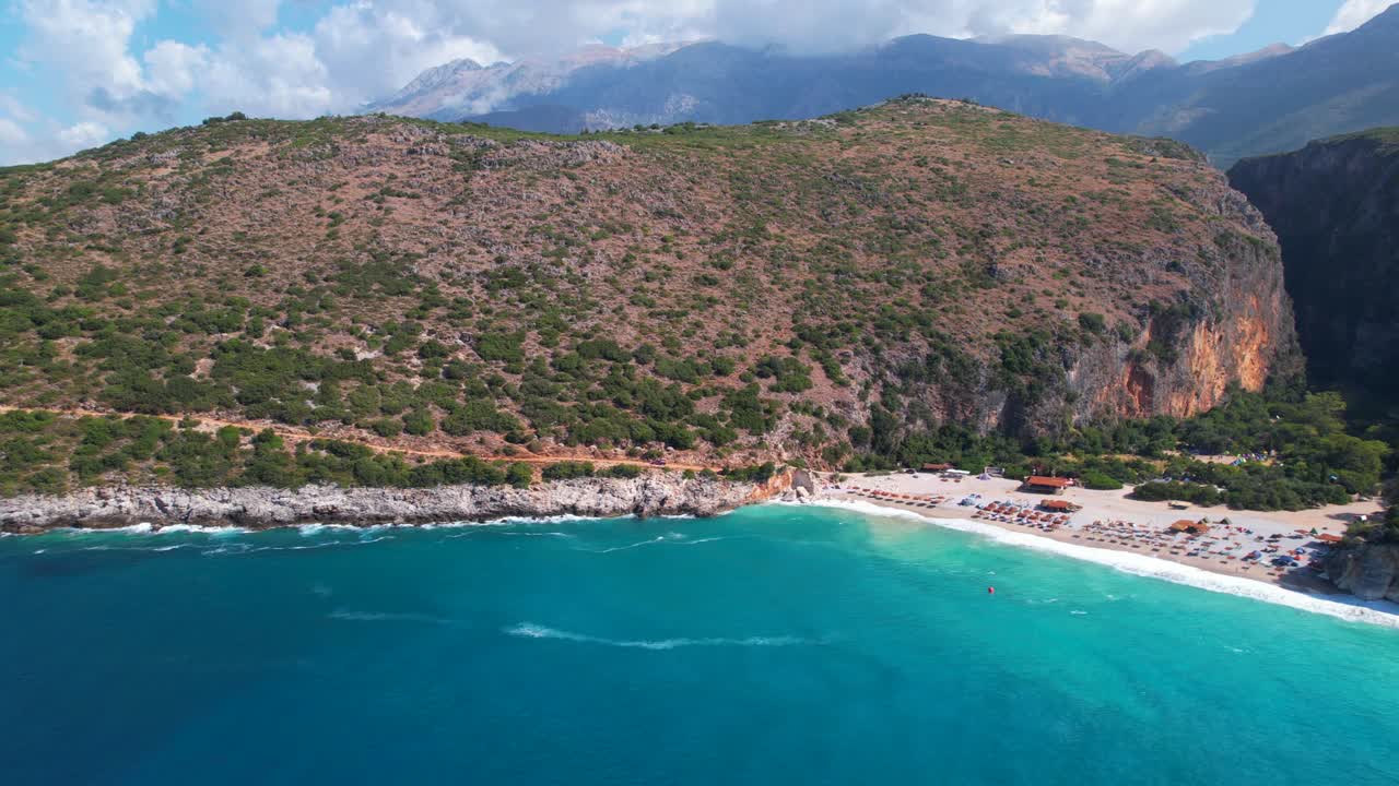 Beautiful bay of Gjipe in Albania with turquoise sea water washing sandy beach on remote tourist destination