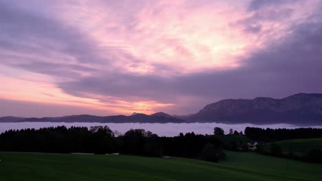 Fiery-sky-awash-in-crimson-hues,-sun-dips-below-horizon,-painting-clouds-in-purple,-pink-and-gold