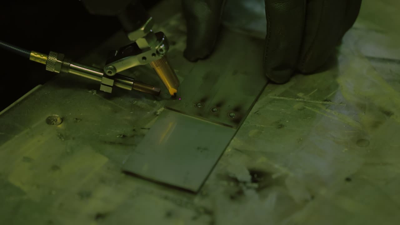 Macchina per saldatura laser con saldatore a pistola. La saldatura laser è mostrata in primo piano