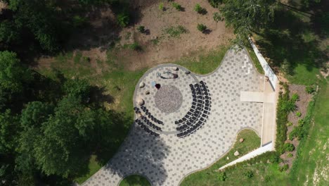 slow aerial top down view of wedding reception circle near forest on sunny day