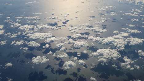 antena de arriba hacia abajo de un grupo de nubes que reflejan sombras en el mar