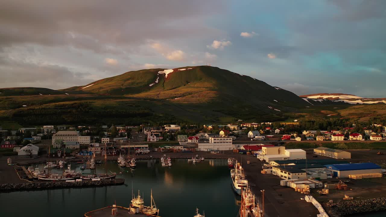 vista escénica de la ciudad histórica de husavik al atardecer con cielo azul y nubes, costa norte de islandia - lado aéreo