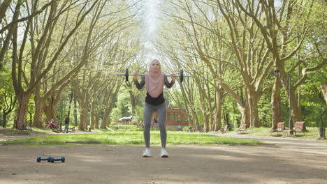 woman in hijab weightlifting outdoors