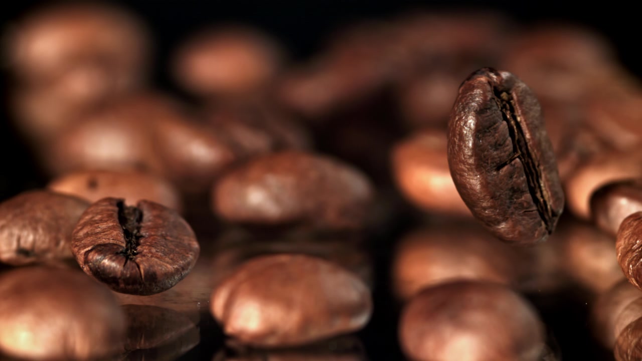 Nærbillede af en ristet kaffebønne, der roterer på mørk baggrund
