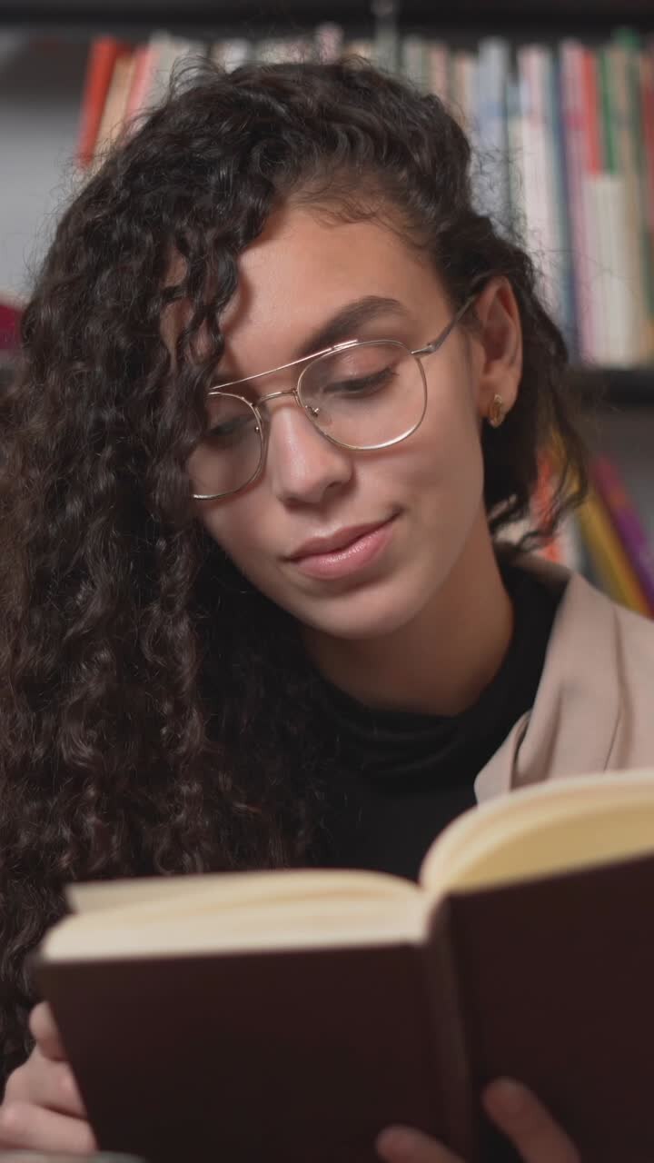 Giovane donna che legge in una biblioteca