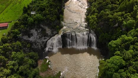 Beautiful-wide-waterfall,-aerial-tilt-up-reveal-scenery-of-New-Zealand-countryside