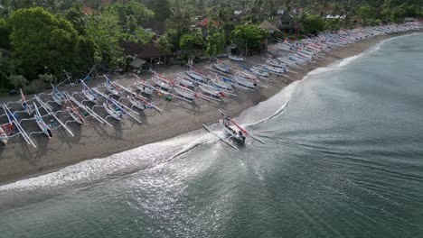 Drohnenansicht-Eines-Traditionellen-Fischerbootes,-Das-An-Einem-Strand-Mit-Dutzenden-Traditioneller-Fischerboote-Landet