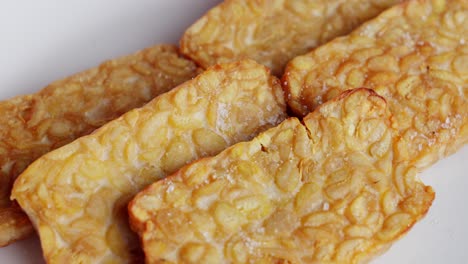 fried tempeh indonesian traditional dish of fermented soy bean with salt sprinkled across thin slices