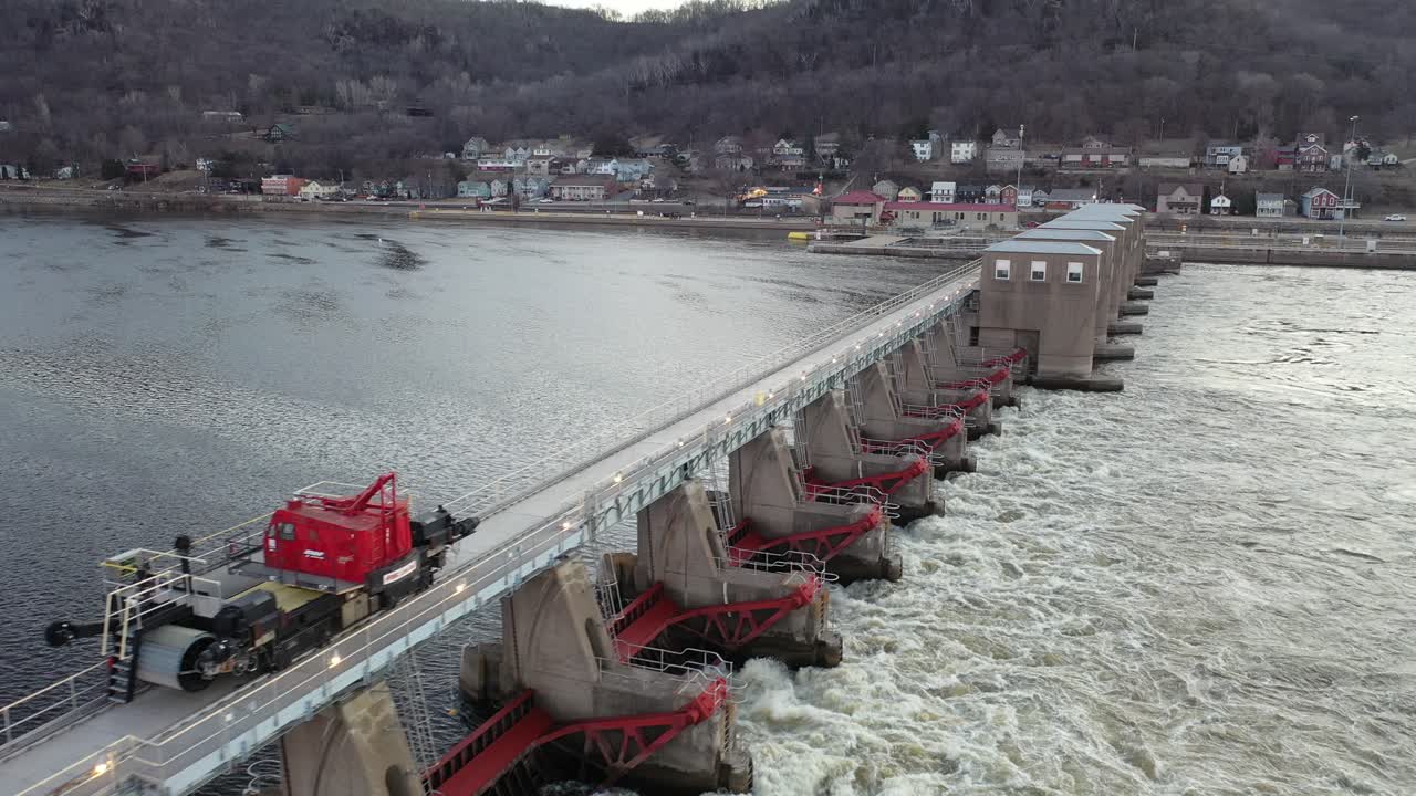 Aerial View of a Large River Dam with a Maintenance Vehicle