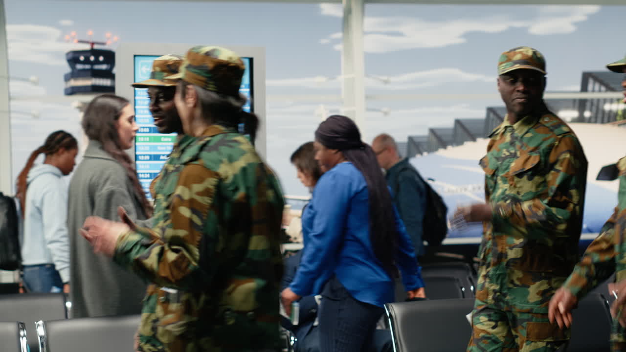 Squadra militare multietnica che cammina in aeroporto, parlando.