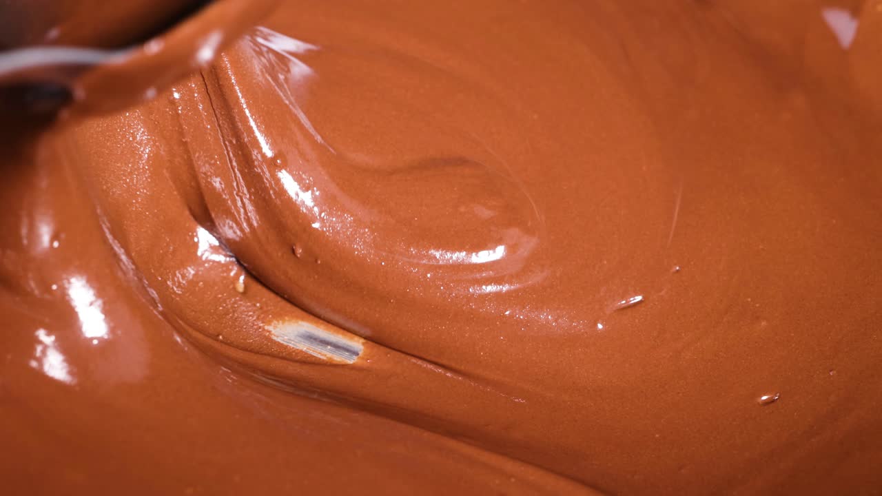 Smooth chocolate being stirred and poured