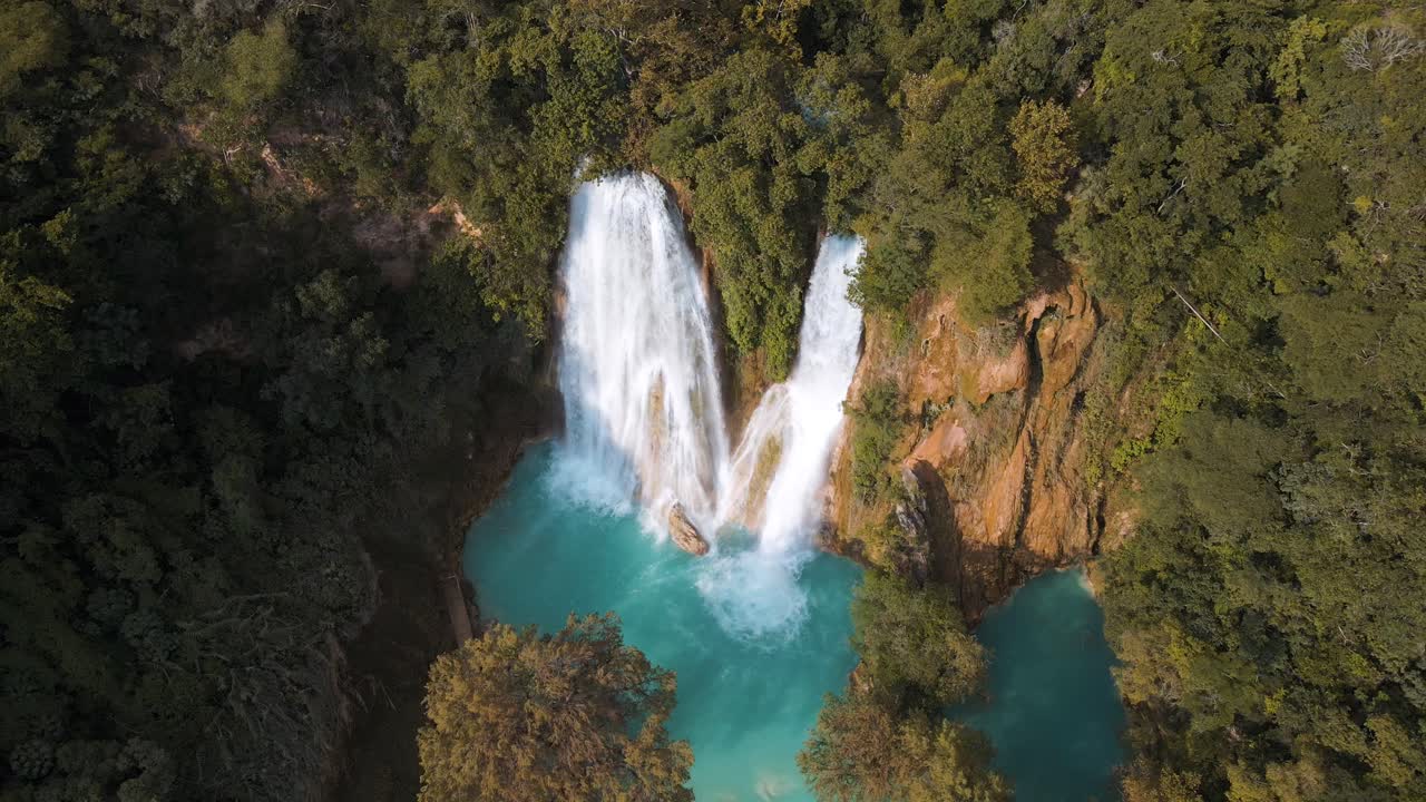 Veduta aerea di cascate paradisiache e un fiume turchese nella foresta tropicale.