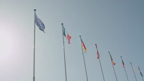 european union flags hoisted and waving in wind against blue sky