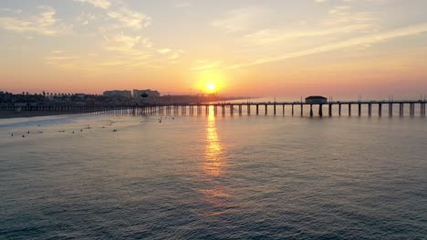 abejón de 4k sunrise en el famoso muelle de huntington beach en surf city, ee. uu., sur de california