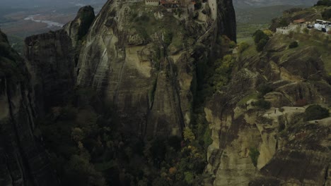 Vista-Aérea-Que-Revela-Un-Monasterio-En-Los-Escarpados-Acantilados-De-Meteora,-En-Grecia---Inclinación,-Disparo-De-Drones