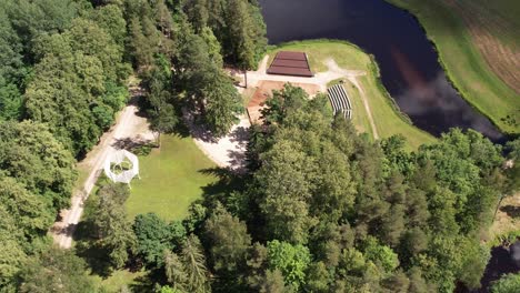 Aerial-view-of-Diklu-Stage-in-Dikli-village,-showcasing-the-open-air-performance-venue-surrounded-by-lush-greenery-and-nearby-buildings