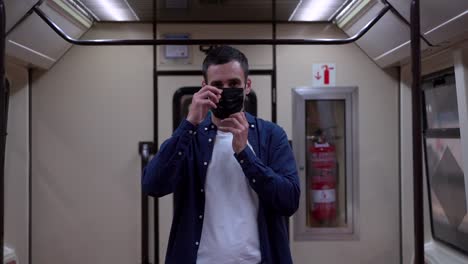 passenger putting on face mask on subway