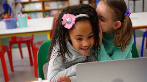 Front-view-of-Mixed-race-schoolgirls-studying-on-laptop-in-the-classroom-4k