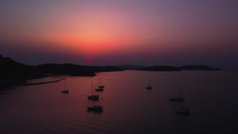 sailboats in the mediteranian sea with beautiful reflections of sunlight on the surface near corfu island - aerial, camera moving right to left.