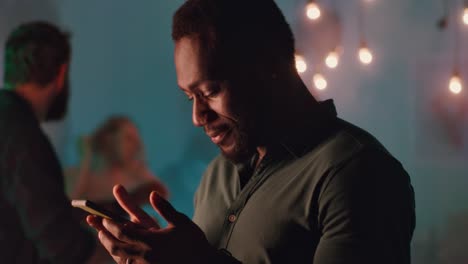 man using smartphone at a night party