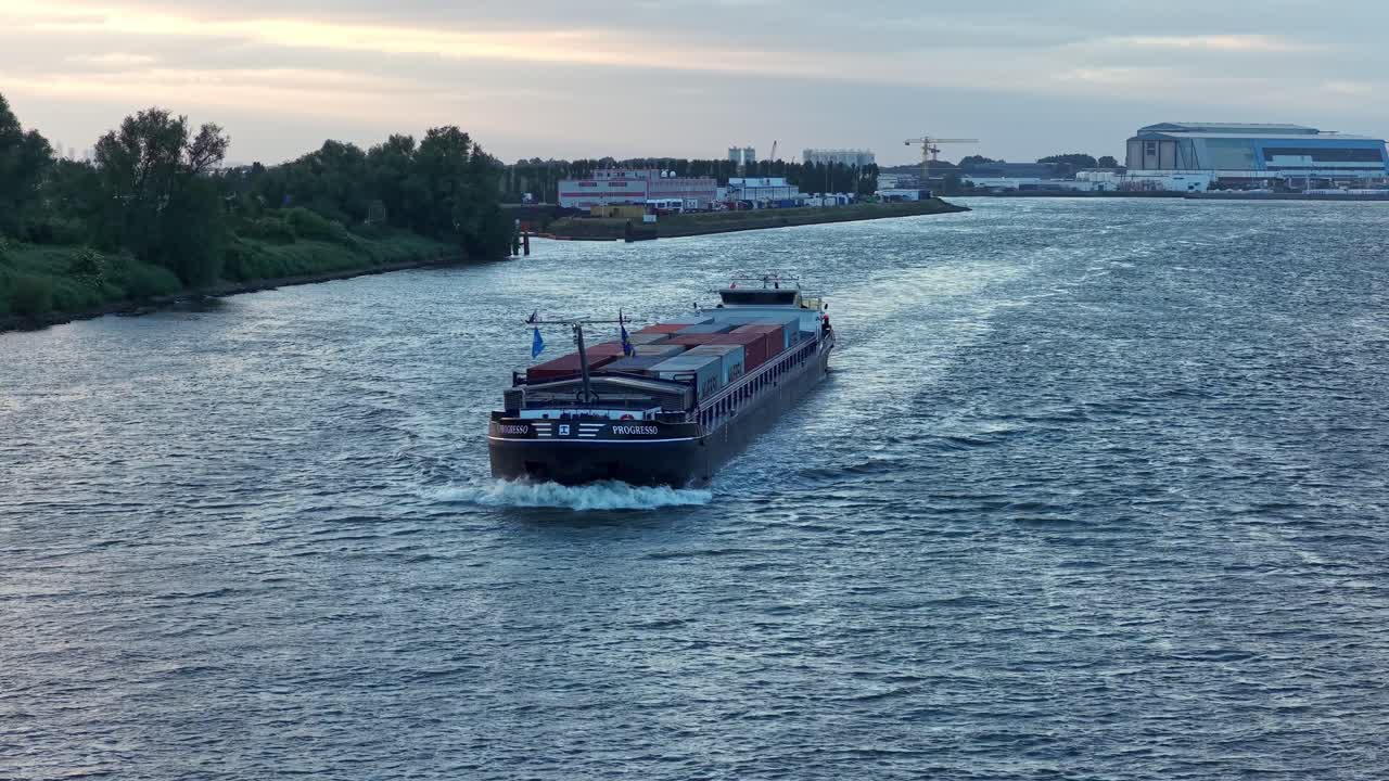 Progresso Dordrecht cargo vessel with multiple containers leaving harbor site of Dordrecht city, Zuid-Holland, Netherlands